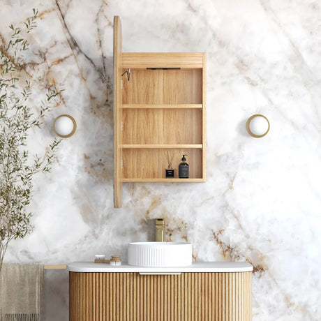 Bathroom with wooden cabinet, sink, and marble wall