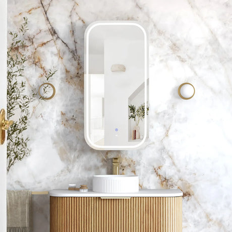Bathroom vanity with a mirror against a marble wall