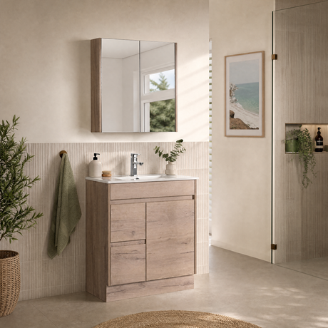 A modern bathroom vanity set featuring a light oak wood cabinet with an integrated white sink, a matching wall-mounted mirror, and a neutral beige tiled wall in a bright, sunlit bathroom.